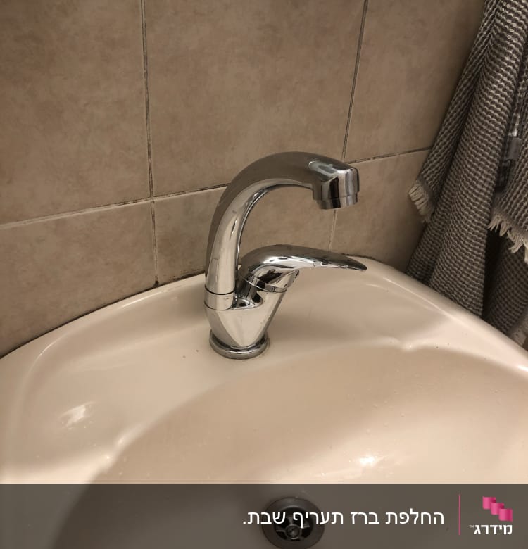 ברז כרום מותקן בכיור לבן בחדר אמבטיה